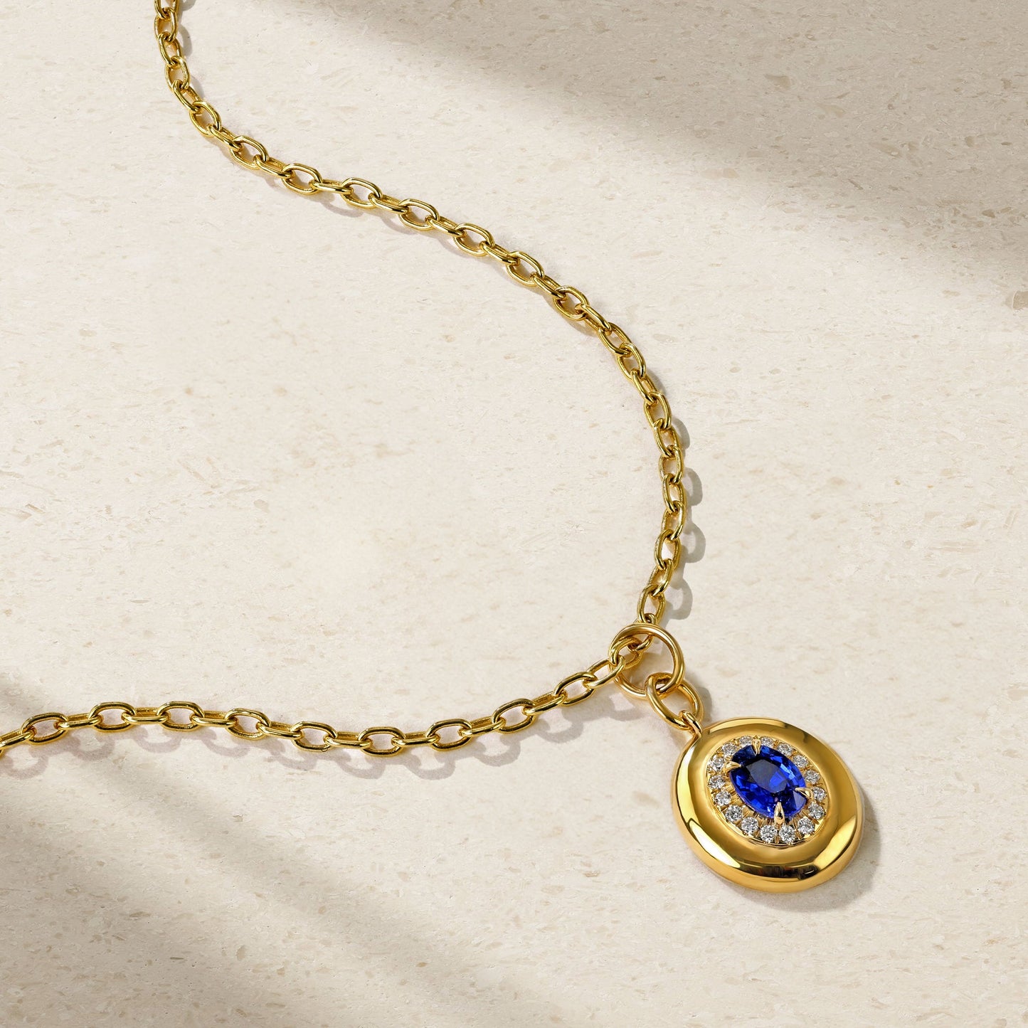 Mark Henry Heirloomed Oval-Cut Sapphire (.86ctw) Pendant with Diamond (.14ctw) Halo. 18k yellow gold on an 16"-18" adjustible chain at Schwanke-Kasten Jewelers.