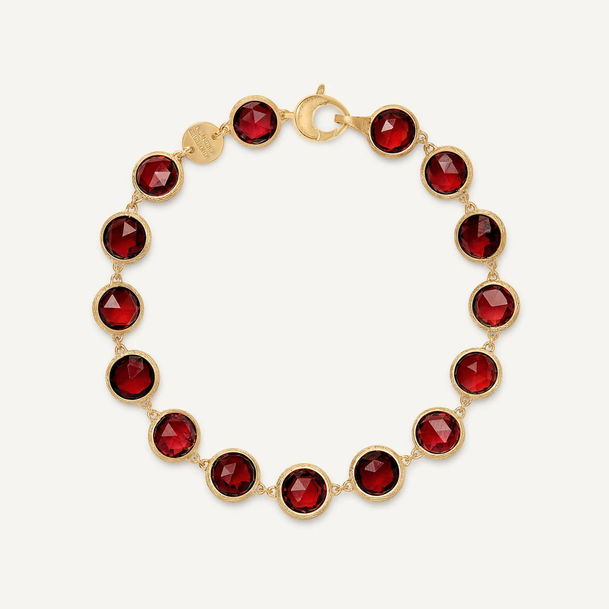 A gold link bracelet featuring ten faceted deep red gemstones in bezel settings, arranged in a circle on a light off-white background.