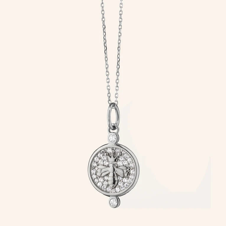 Silver necklace with a round pendant on a white background