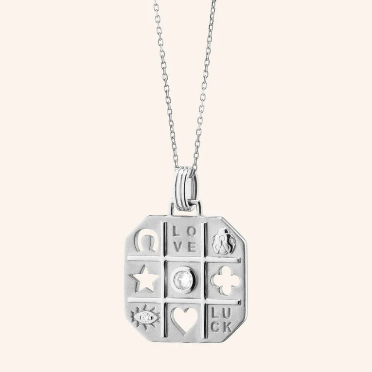 Silver pendant necklace with various symbols on a white background