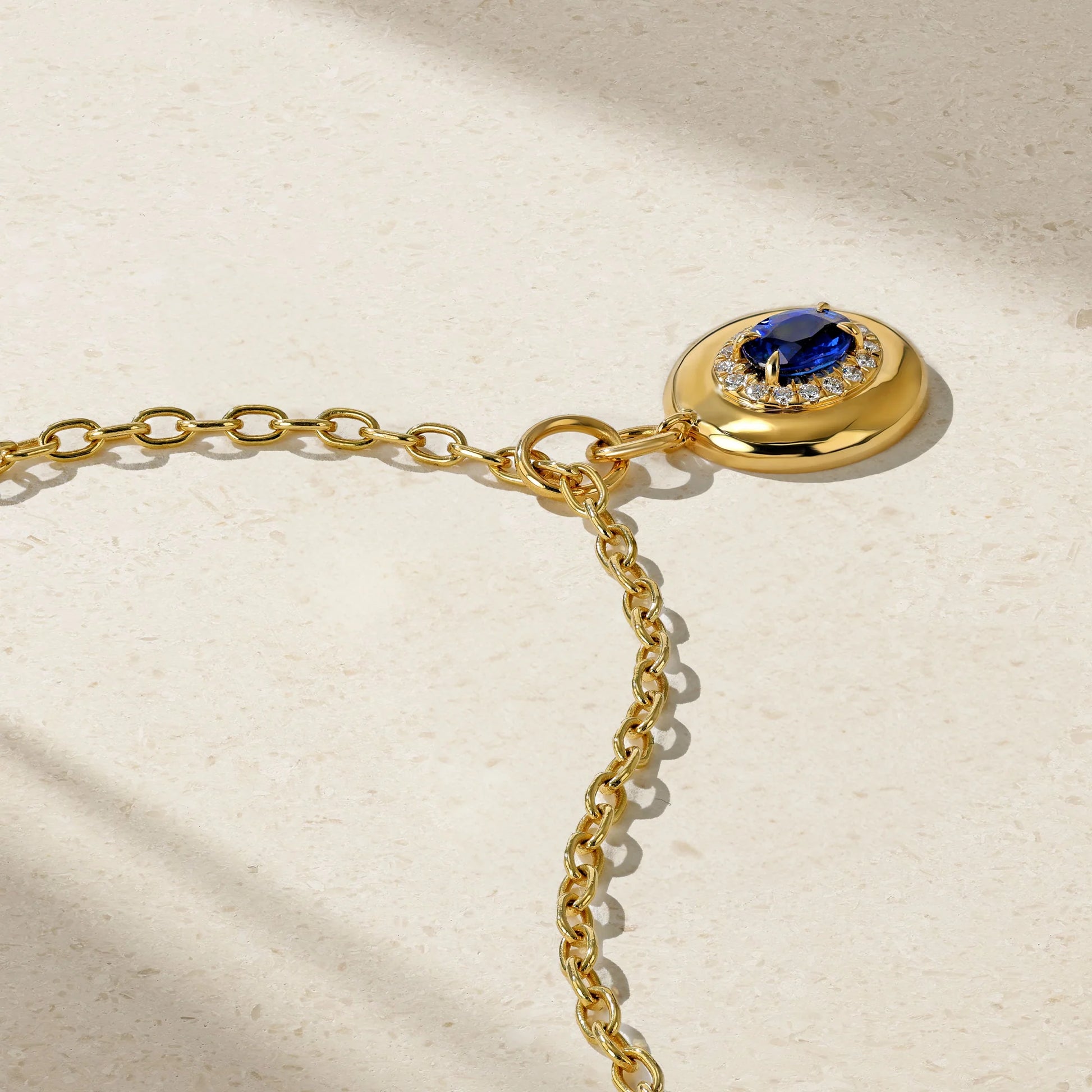 Mark Henry Heirloomed Oval-Cut Sapphire (.86ctw) Pendant with Diamond (.14ctw) Halo. 18k yellow gold on an 16"-18" adjustible chain at Schwanke-Kasten Jewelers.