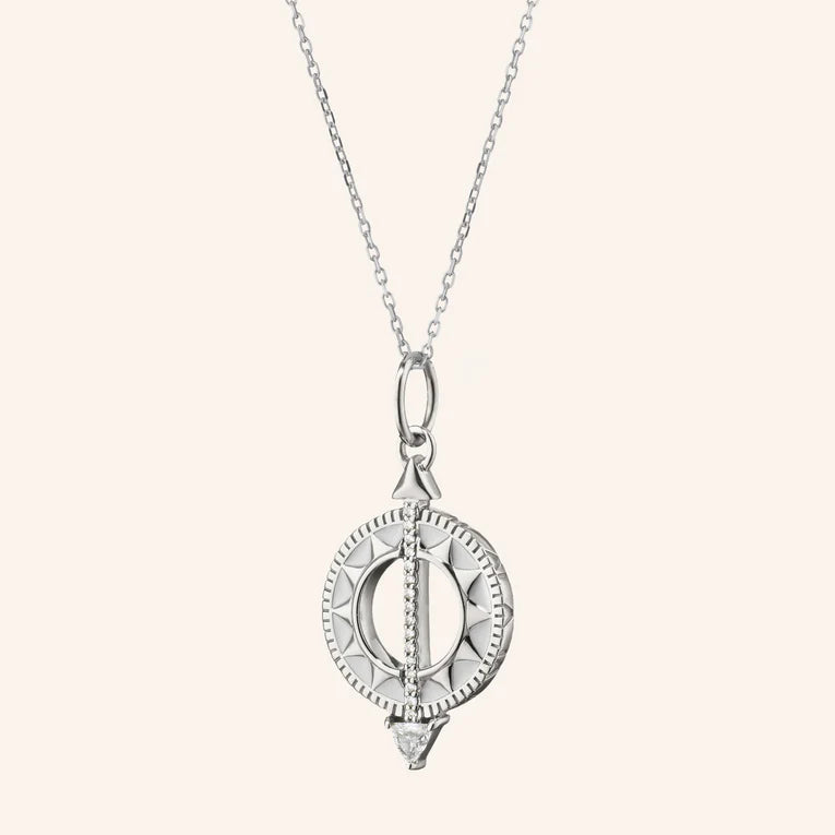 Silver pendant necklace on a light beige background