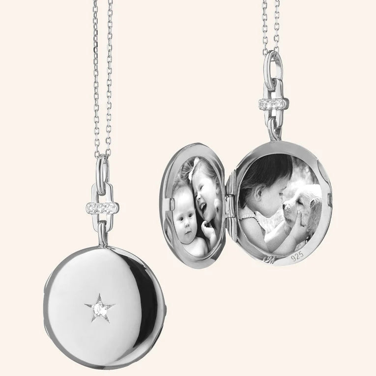 Silver locket with two round faces showing a baby, on a white background