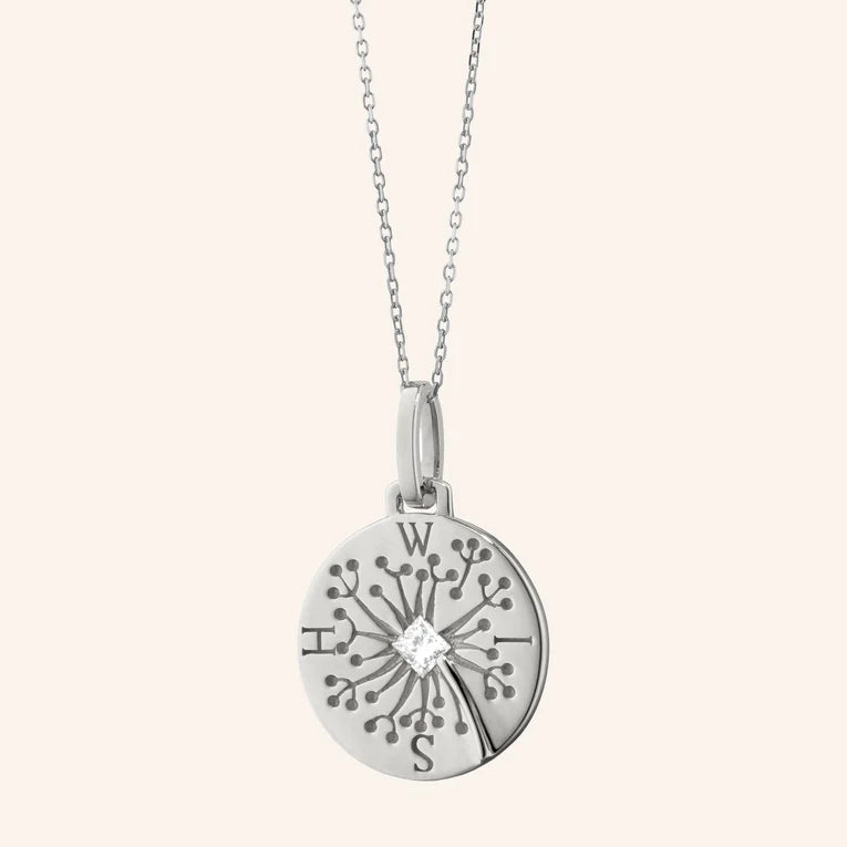 Silver pendant necklace with intricate design on a white background