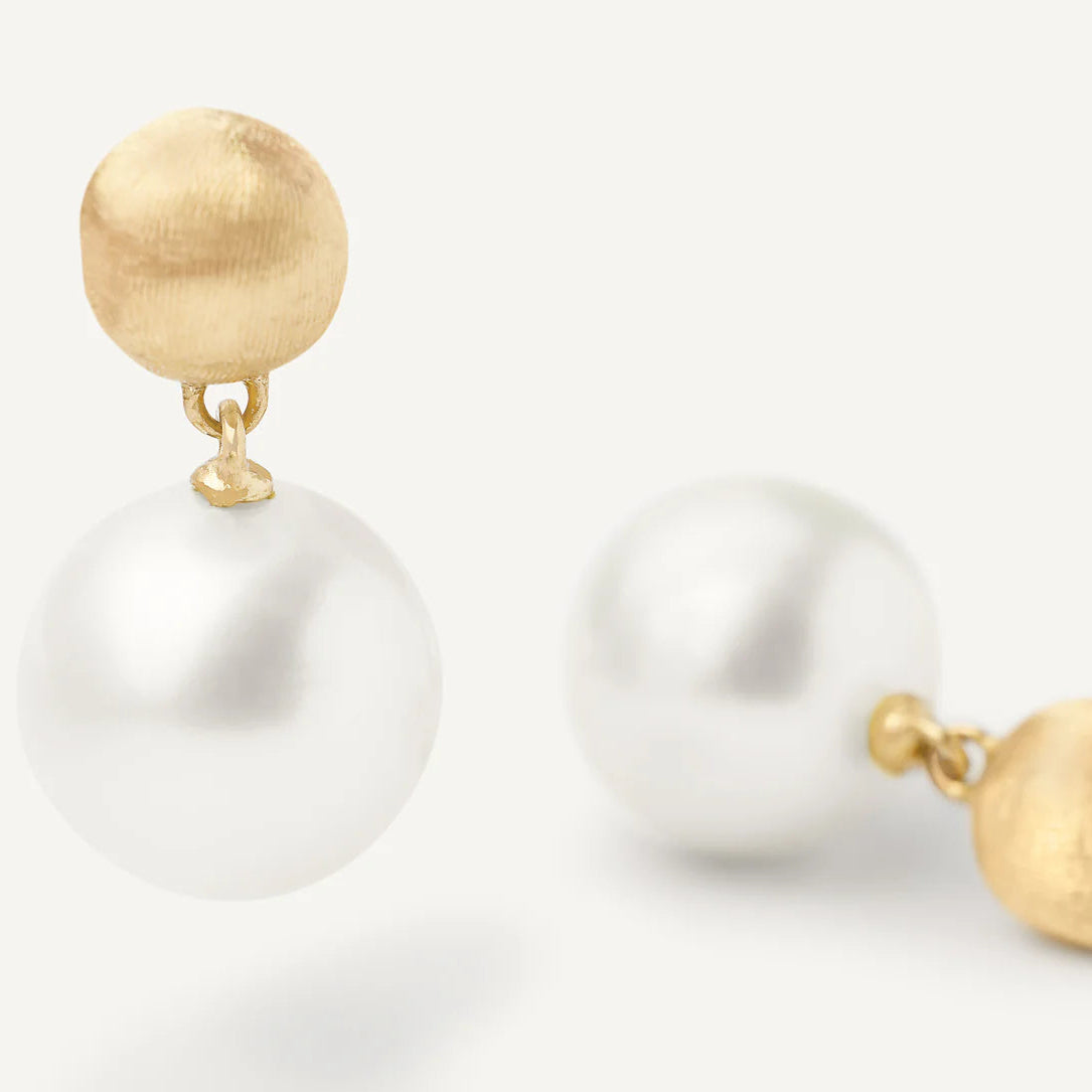 Pearl earrings with gold tops on a white background