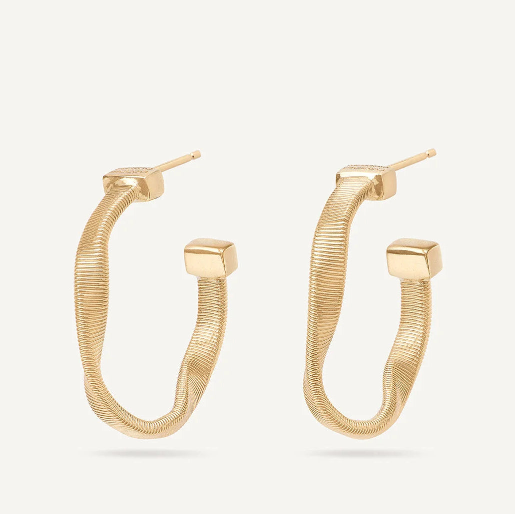 A pair of gold hoop earrings with a textured, snake-like coiled design and a polished square connector at the end of each hoop, shown on a light off-white background.