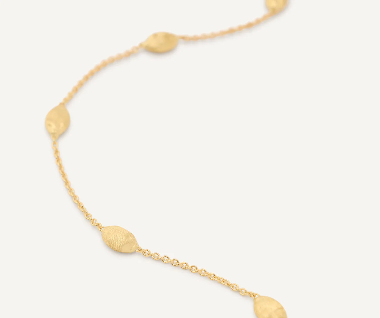 Gold necklace with round pendants on a white background